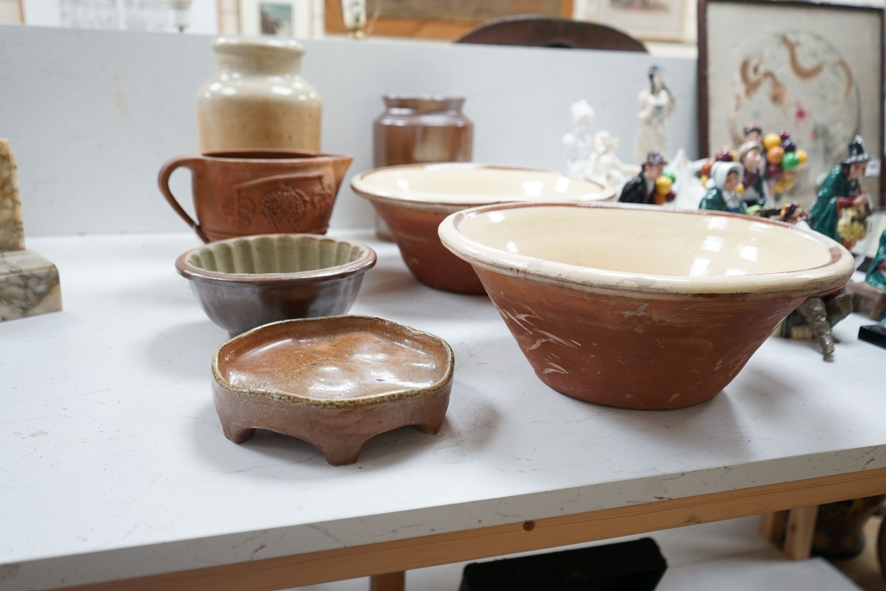 Two Victorian stoneware jars, tallest 33cm, together with two Victorian dairy bowls, a stoneware trivet, a jelly mould and a terracotta jug (7)